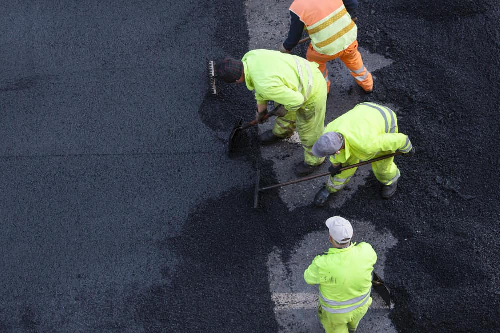 workers-during-asphalting-road-work-city-street-asphalt-paving-high-angle-view-copy-space-1